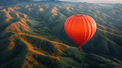 Obraz premium Orange Hot Air Balloon Soaring Over Rolling Hills