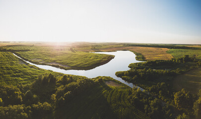 A Serene Aerial View of a Peaceful Lake Winding Through Verdant Fields