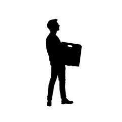 Silhouette of a man carrying a heavy box in front of him