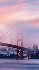 Obraz premium Goldene Brücke im Nebel bei Sonnenuntergang über der Stadt