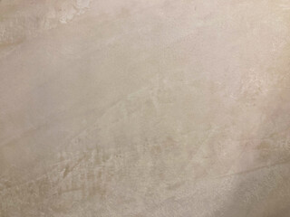 Close-up image of a textured stone or concrete surface, with natural color variations and a sense of depth from an angled view The focus is on the texture and play of light