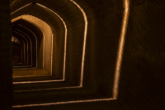 Stairs downward to the water reservoir in Yazd, Iran illuminated by ornamental lighting. 