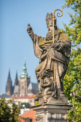 Fototapeta premium Religious statue of Augustine of Hippo mounted to the balustrade of Charles Bridge in Prague, Czech Republic