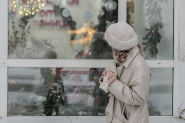 A girl walks through a city decorated for Christmas in winter