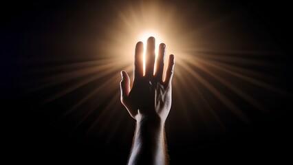 Fototapeta premium A man's hand reaches out to the light in the darkness, his silhouette clearly outlined against a distant beam of warm light. The scene captures a moment of hope and aspiration.