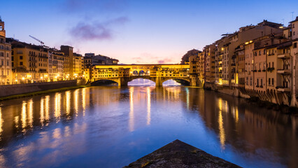 Ponte Vecchio bridge acros arn river .Only surviving bridge from world war 2 glowing in morning sun light and colorful sky, Florence Italy