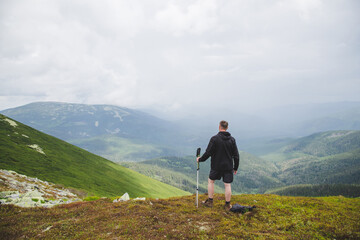 Fototapeta premium Rear view of young man hiker traveling in the Carpathian Mountains. Gorgany range