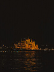 Fototapeta premium Beautiful photograph of the Hungarian Parliament Building in Budapest at night, illuminated against the dark sky. 
