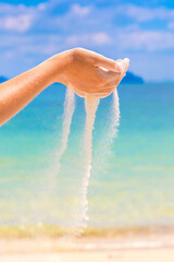 Sand falling through woman hands