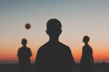 Fototapeta premium A boy is standing in the middle of two other boys, with a soccer ball in the air