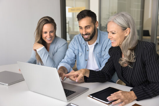 Creative department working on project using laptop, look at device screen with interested expression, developing marketing campaign or strategy, exploring market trends, review new corporate software