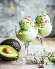 Avocado ice cream in transparent glasses with edible flowers