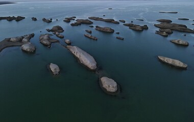 Isolated Serenity: Rock Formations in Calm Waters at Dusk