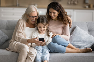 Leisure time online. Happy diverse age female family members mature granny millennial mum parent...