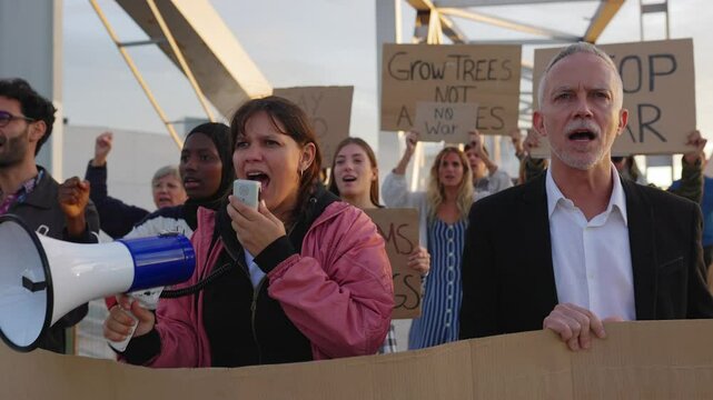 Multiethnic protesters peacefully rallying on urban street, raising environmental awareness through megaphones and signs supporting ecological justice