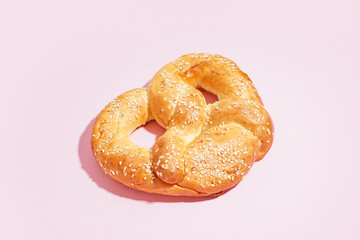 Tasty pretzel on pink background