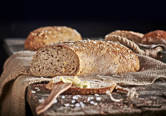 Chleb wieloziarnisty na drewnianym stole z masłem © Jolaya