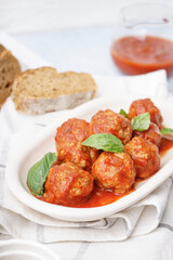 Plate of tasty meat balls with tomato sauce and basil, closeup