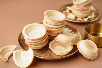 Plate with homemade tartlets on brown background