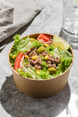 salad with tuna, tomatoes, cucumber and olives in container