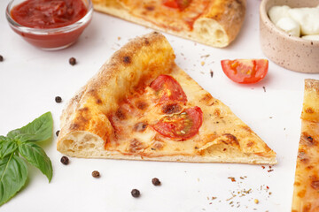 Pieces of tasty pizza Margarita with tomatoes and basil on white background