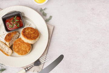 Plate with tasty meat cutlets and sauce on white background