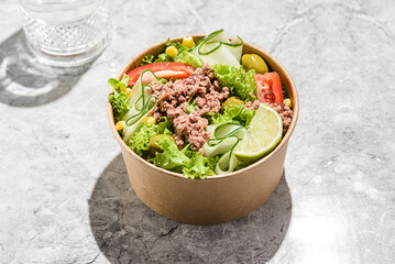 salad with tuna, tomatoes, cucumber and olives in container