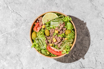 salad with tuna, tomatoes, cucumber and olives in container