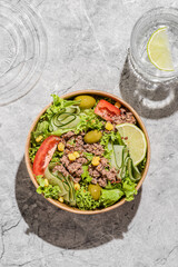 salad with tuna, tomatoes, cucumber and olives in container