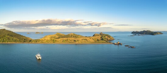 Aerial view of a catamaran in calm waters near islands. Tranquil scenery. Motukawanui Island, Bay...
