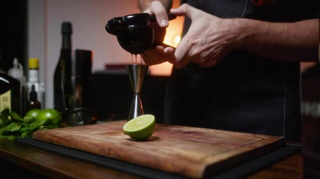 Crafting a cocktail in a cozy home bar. Intimate setting with fresh lime and squeezer. Perfect for mixology tutorials or lifestyle vlogs.