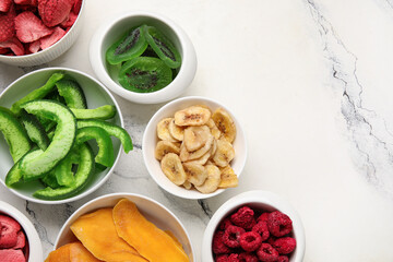 Bowls of different dehydrated fruits and berries on white background