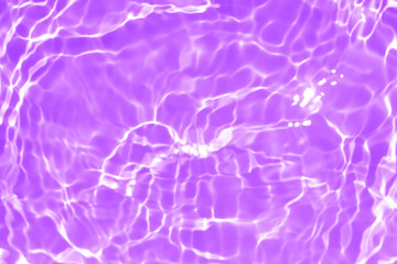 Purple water with ripples on the surface. Defocus blurred transparent white colored clear calm water surface texture with splashes and bubbles. Water waves with shining pattern texture background.