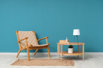 Armchair and coffee table with desk lamp near blue wall