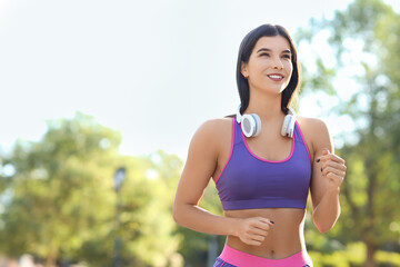 Fototapeta premium Sporty young woman jogging in park