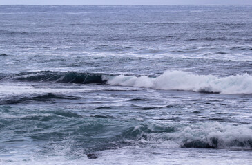 Vast expanse of the ocean with white-capped waves breaking across its surface