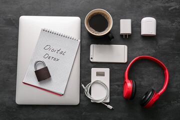 Set of different modern gadgets, notebook with text DIGITAL DETOX and cup of coffee on dark background