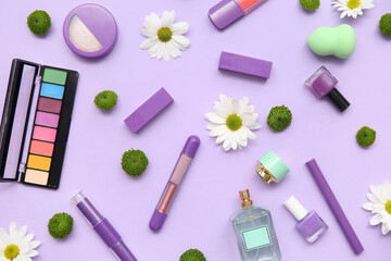 Bottle of perfume, nail polish, makeup products and flowers on lilac background