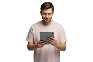Man focused on tablet screen while standing indoors in casual attire and light environment