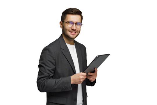 Young man in a suit smiling while holding a tablet in a bright setting