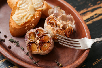 Plate with baked garlic, peppercorns, crouton and thyme, closeup