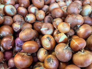 Raw onions on a supermarket counter.