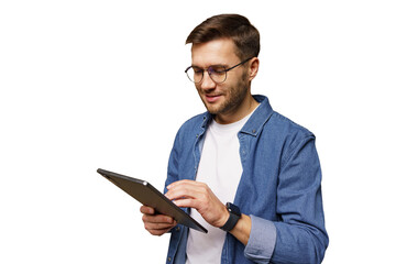 Man wearing glasses using a tablet while standing and smiling happily indoors