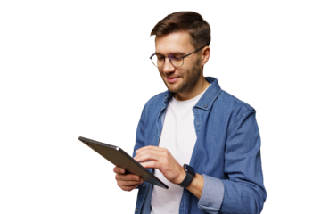 Man wearing glasses using a tablet while standing and smiling happily indoors