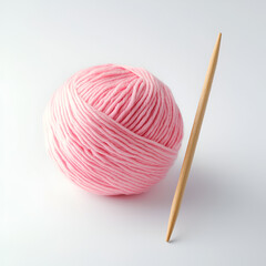 Soft pink yarn ball and knitting needle on white background. Perfect for crafting projects and DIY enthusiasts.