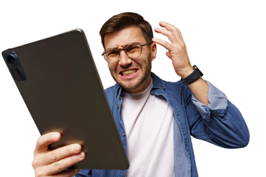 Frustrated man looking at tablet in office setting while expressing annoyance over technology issues