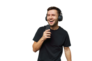Young man enjoys singing while wearing headphones and holding a smartphone in a bright setting