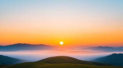 Obraz premium Serene sunrise over rolling hills with misty valleys and distant mountains at dawn