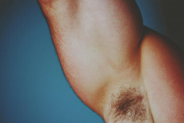 Fototapeta premium A man with a hairy chest is shown in a blue background