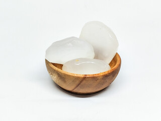 Lontar fruit, also known as toddy palm or palmyra fruit (Borassus flabellifer) in wooden bowl isolated white background.